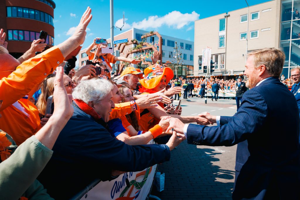 Koning WIllem-Alexander schudt handen met publiek