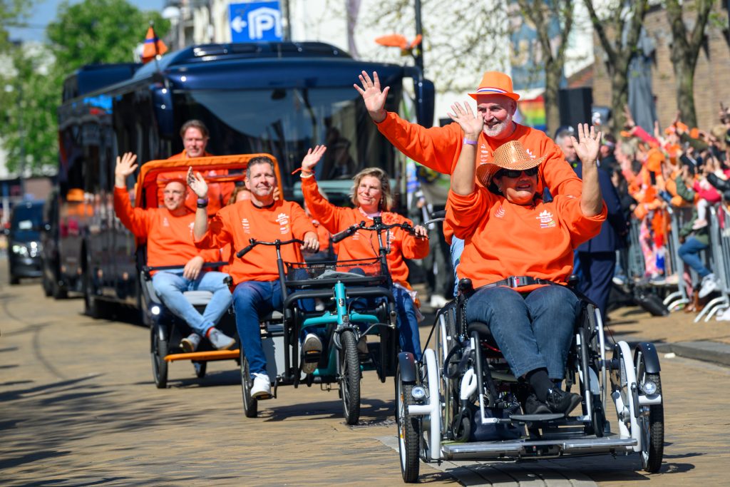 Duofietsen fietsen voor de koninklijke bus uit op de welkomstlaan