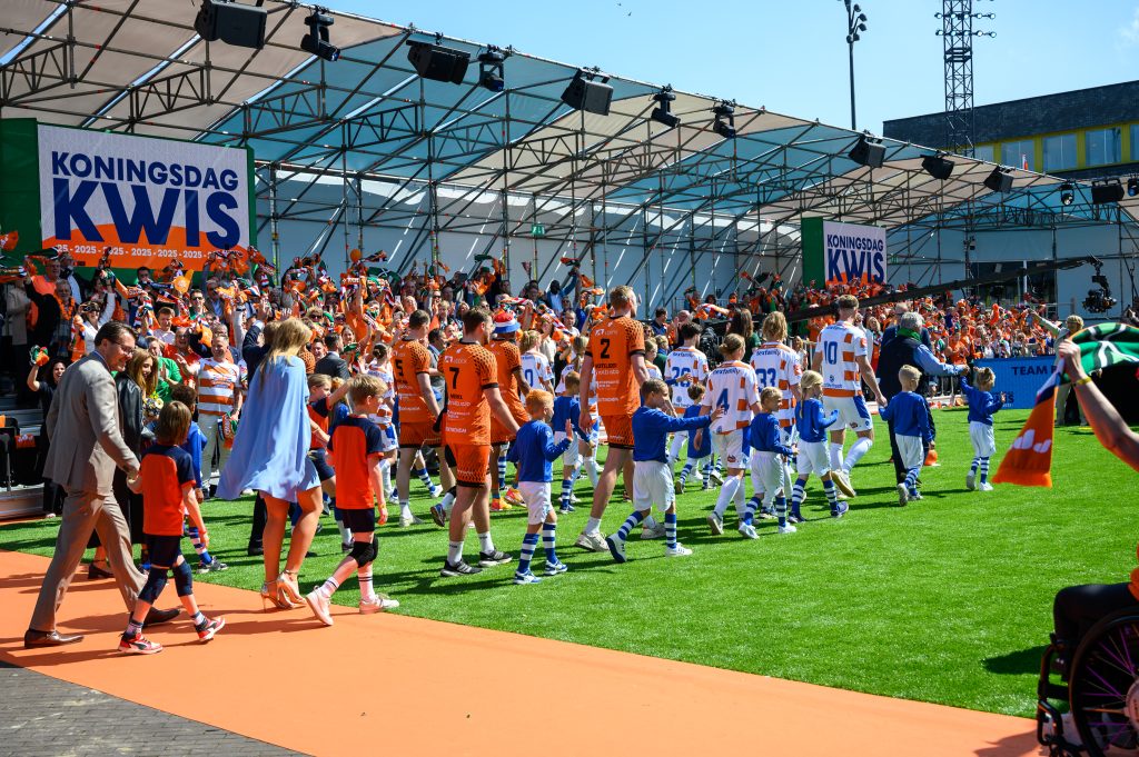 Spelers van Orion en de Graafschap betreden stadion de Kleine Vijverberg samen met leden van het Koninklijk Huis