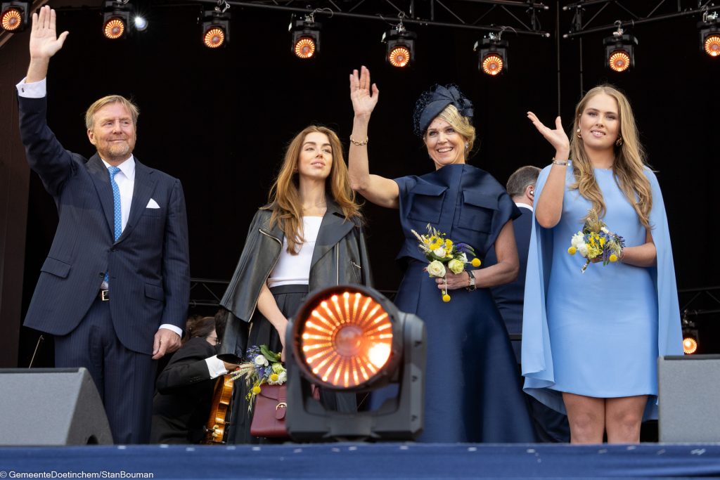 Het koninklijk gezin zwaait vanaf het eindpodium naar het publiek