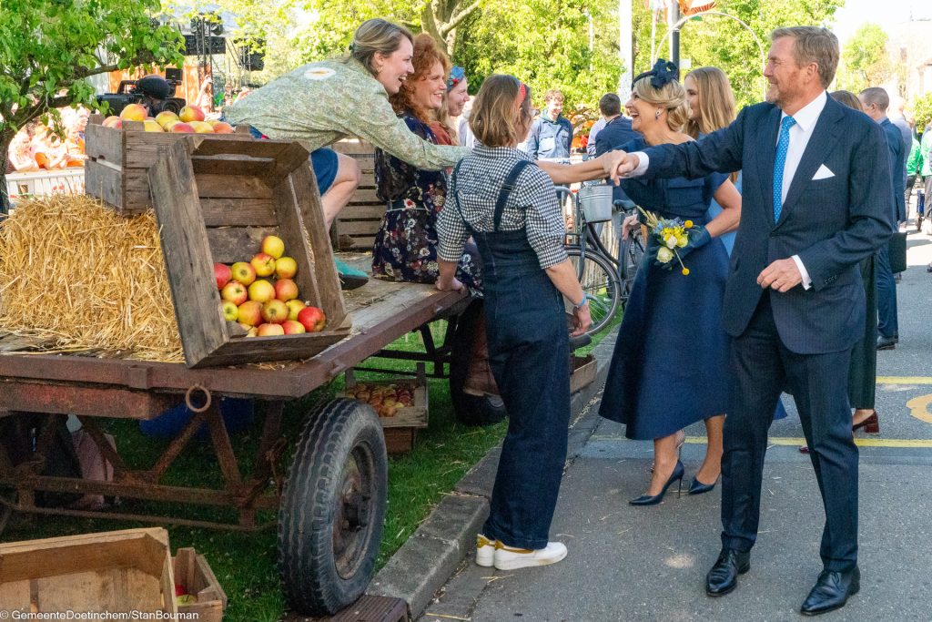 Willem-Alexander en Maxima schudden handen bij het onderdeel van de stadsboerin